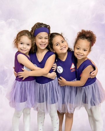 Quatro alunas da turma de ballet, abraçadas, com o uniforme roxo da escola